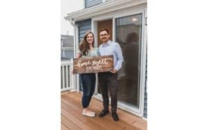 Old Mill Group Real Estate Couple celebrating first home with homemade sign
