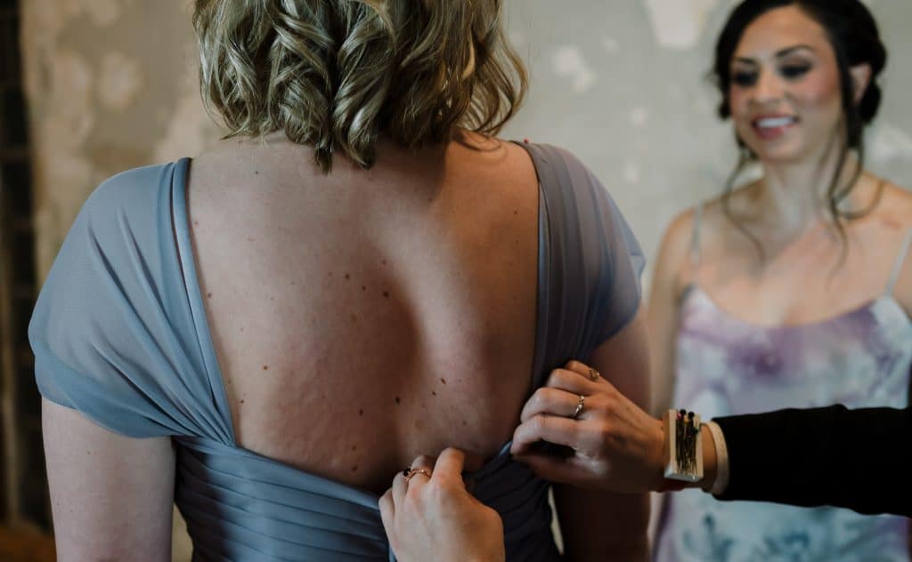 Glenwood South Tailor and Alterations - Bridesmaid getting back of dress altered - Forever Bridal Wedding Shows