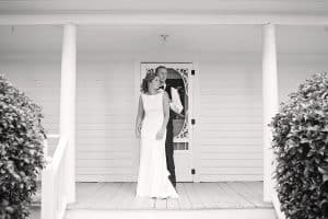 Bride and Groom standing on the porch of the Harvest House in North Carolina - KStar's Photography- Forever Bridal Wedding Shows