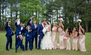Couple kissing with Wedding Party-rose gold sequin bridesmaid dresses-blue suits for groomsmen-KStar'sPhotography-Forever Bridal Wedding Shows