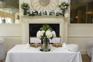 White bouquet on table in front of fireplace