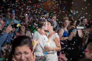Will Greene Photography - bride and groom kissing in confetti - Forever Bridal Wedding Shows