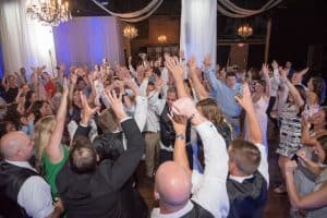 Dow Oak Events image of everyone raising their hand while dancing at reception