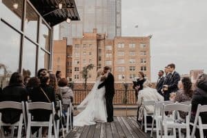 Bride and Groom Kissing on an outdoor patio in downton Raleigh, North Carolina - The Glass Box - Forever Bridal Wedding Shows