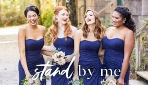 Four bridesmaid standing together in a classic blue gown, holding their boquets