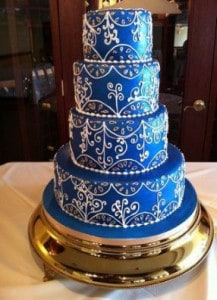 Four tiered royal blue cake stenciled with designs