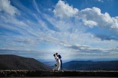 Photo of couple at North Carolina Blue Ridge Parkway surrounded by the blue sky and mountains