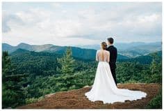 Photo of couple at North Carolina Blue Ridge Parkway looking at the sky and blue mountains