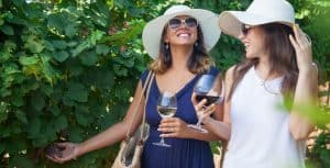 Two ladies drinking wine - cruise planners - vicki sells vacations - forever bridal wedding shows