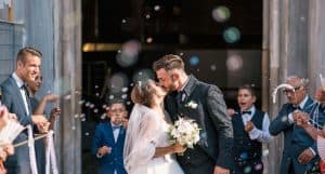 bride and groom kissing in front of church