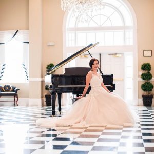 Bride in Simply Blush Wedding Gown on a Piano