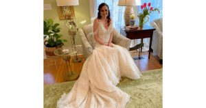 Sinderellas Rockefellas Bridal Boutique bride in beaded wedding gown, sitting in chair indoors