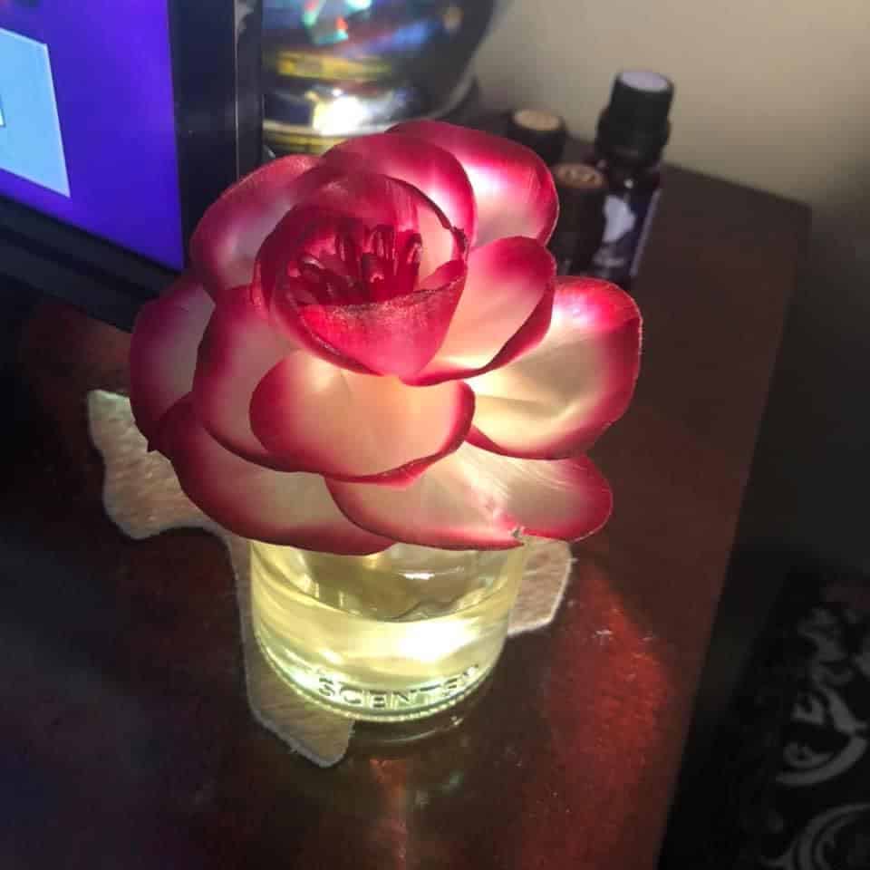  A pink faux flower that is lit up. 