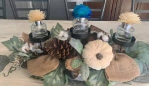 A table display with a pumpkin and pine cone