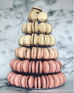 A six-tiered Mon Macaron tower colored in a pink to beige ombre effect