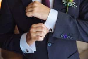 The hands of a man who is wearing a suit.